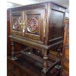 A Breton oak side cabinet with 2 carved and pierced wheel-design panelled doors, on turned legs,