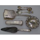 A box of silver items, to include 2 silver-backed brushes, a silver and enamel spoon for L.C. Lodge,