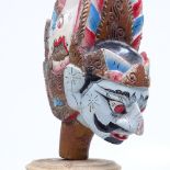 A carved and painted Eastern Thai Wayang Golek puppet's head on stand, 25cm overall