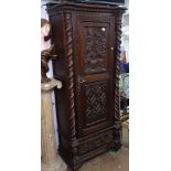 A 19th century carved oak hall cupboard, with single panel door and barley twist pillisters,
