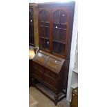 A 1920s panelled oak bureau bookcase, W90cm