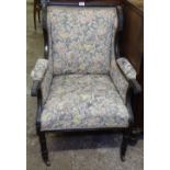 An Edwardian upholstered and mahogany-framed armchair on turned legs