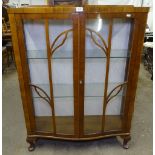 A 1930s walnut serpentine-front display cabinet, with 2 glazed doors, W89cm