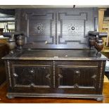 A 1920s panelled oak monk's bench, W102cm