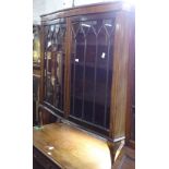 A 1930s mahogany serpentine-front display cabinet, with 2 lattice-glazed doors, on cabriole legs,