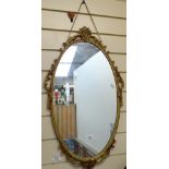 An oval wall mirror in pierced gilt frame, height 66cm