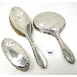 A silver-backed dressing table brush and mirror, and an oval cut-glass trinket box with silver lid