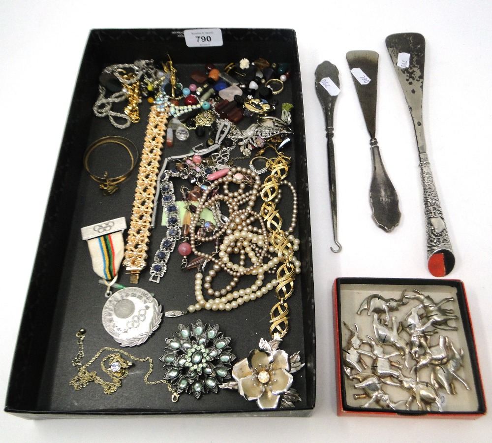 A box containing silver-handled shoe horn, a button hook, an Olympic medal, menu holders, costume