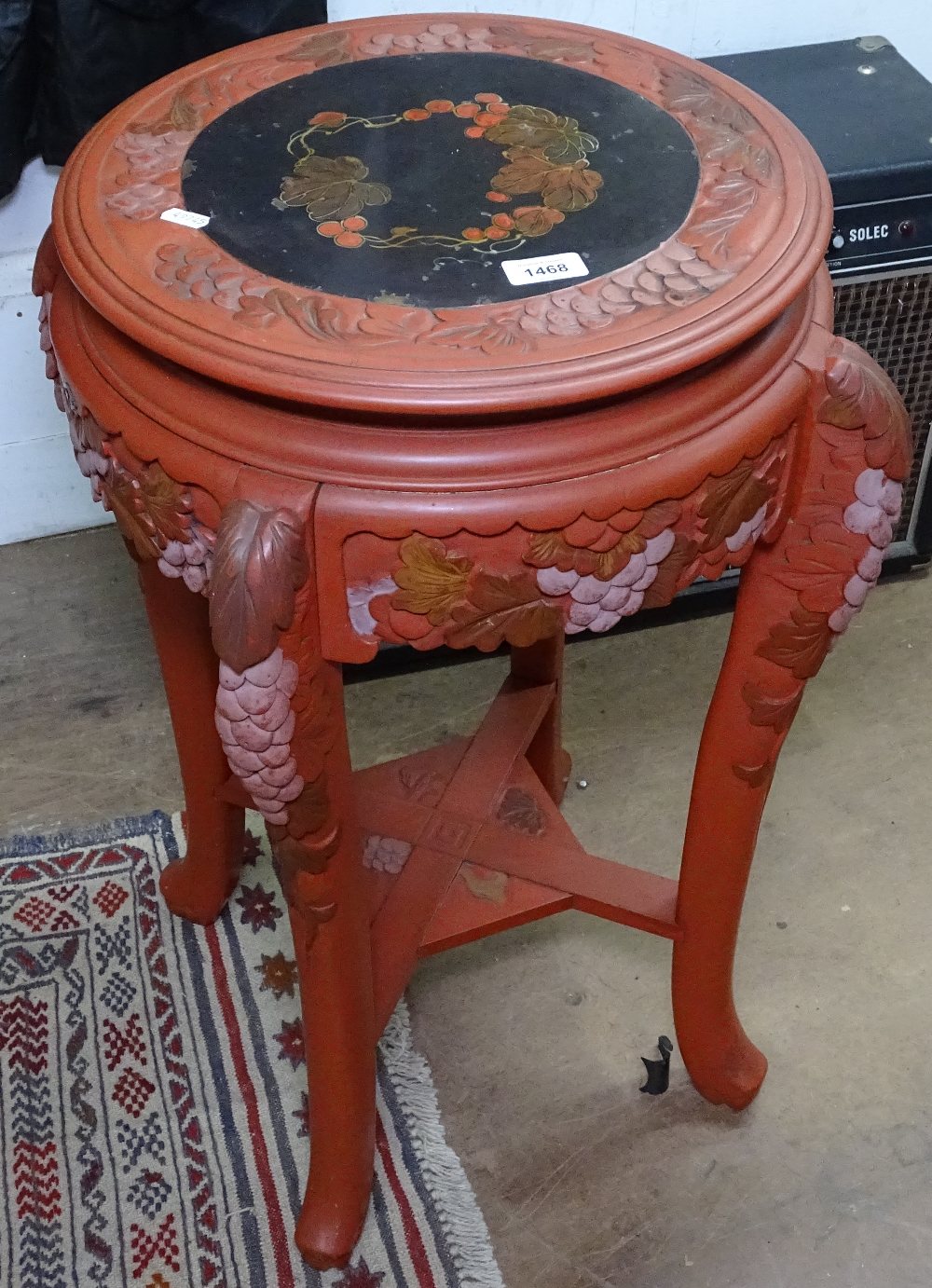 An Oriental red lacquered jardiniere stand with carved decoration, on cabriole legs, W45cm, H72cm