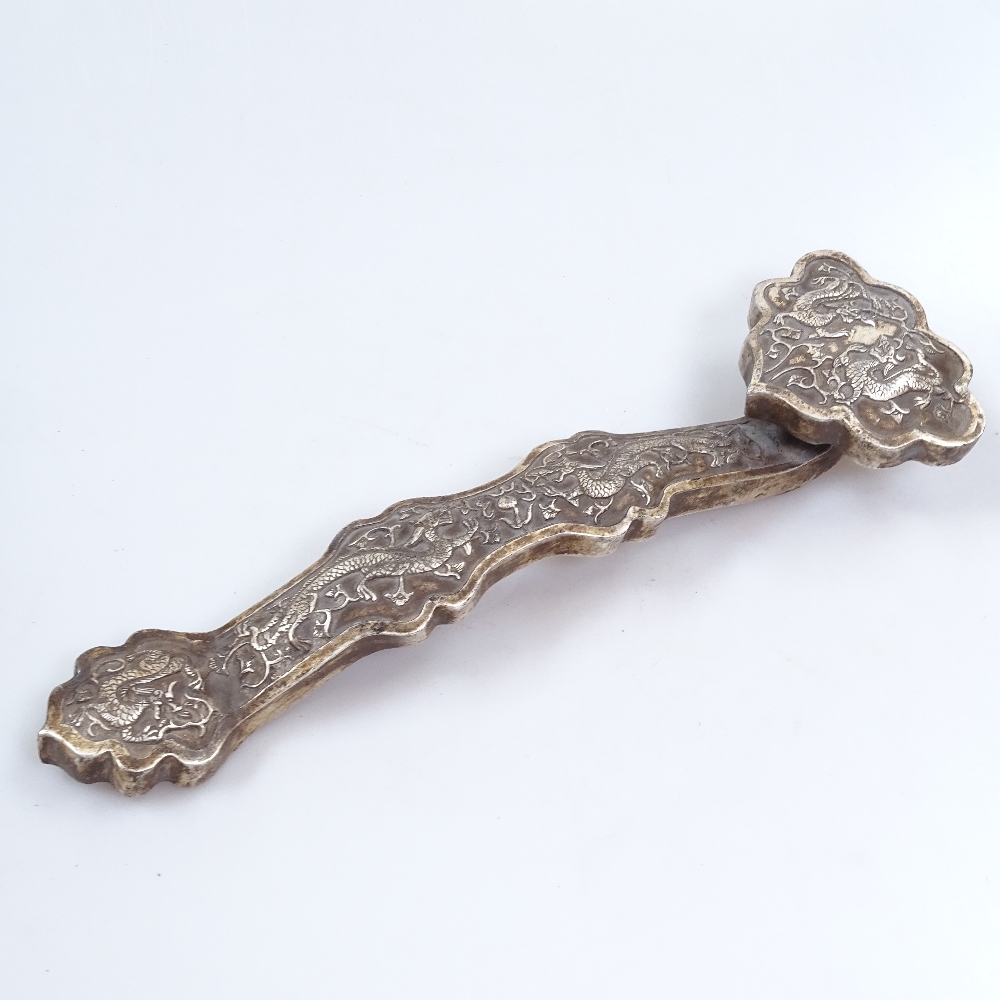 A Chinese embossed white metal sceptre, 35cm