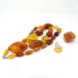 A large strand of specimen amber beads, 175g, and an amber set ring