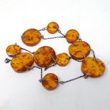 A silver and Baltic amber panel necklace, largest panel diameter 32mm, length 35cm