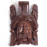 A carved wood mask with glass eyes, height 25cm