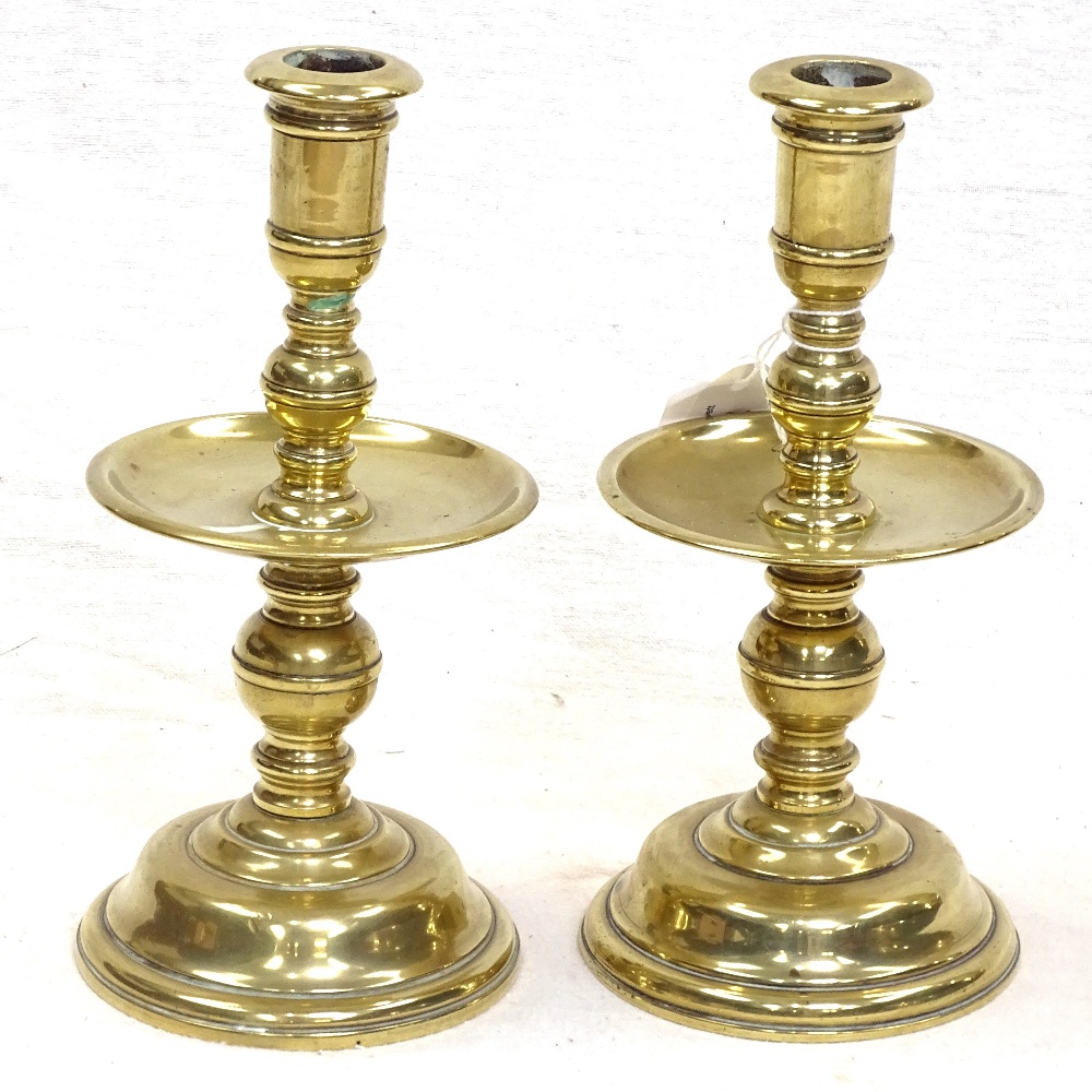 A pair of brass candlesticks with large drip pans, 18.5cm