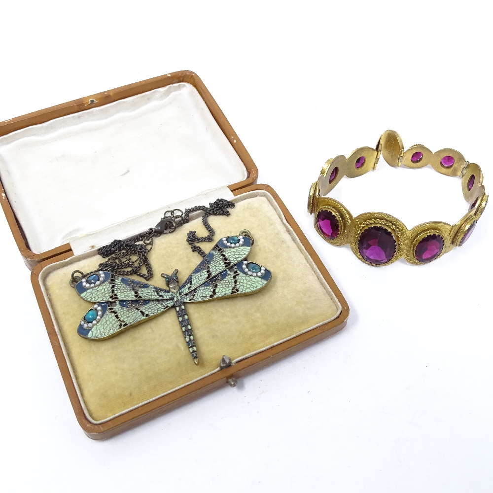 A red stone set and gilt-metal bracelet, and a green enamel dragonfly pendant and chain (2)