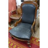 A Victorian carved oak-framed open armchair with fluted legs