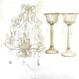 A wicker basket, a pair of candle stands, and a chandelier