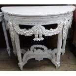A decorative white painted demilune console table, with floral carved frieze and fluted legs, W97cm,