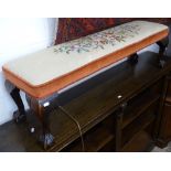 An Edwardian tapestry upholstered fender stool, on claw and ball feet, L110cm