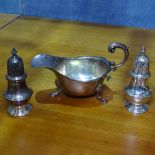 A pair of silver pepperettes, height 10cm, by Garrad & Co, and a small silver sauce boat, 5.8oz