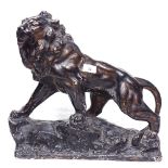 A painted plaster moulded figure of a lion on rocks, height 42cm