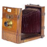 A 19th century mahogany plate camera having burgundy bellows