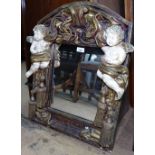 A decorative painted and gilded plaster arch-top wall mirror, with cherub mounts, W50cm, H65cm