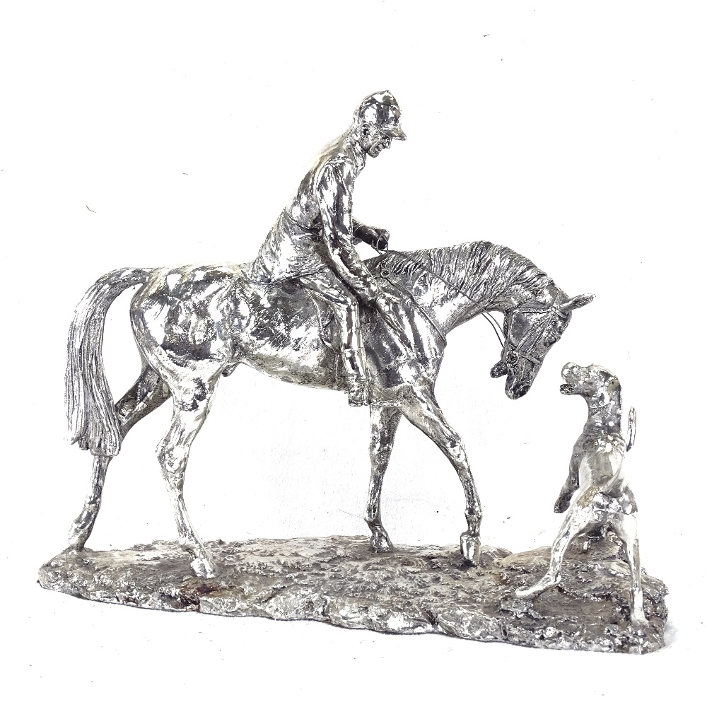 A silvered sculpture of a horseman and hound, height 26cm