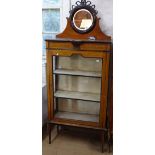 An Edwardian mahogany display cabinet, with raised mirror-back single glazed door, raised on