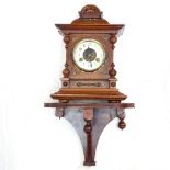 A carved oak-cased 2-train clock, height 35cm, and a mahogany bracket