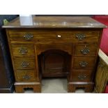 An early 20th mahogany knee-hole writing desk, with 7 fitted drawers and recessed panelled cupboard,