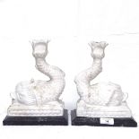 A pair of carved marble dolphin candlesticks on marble plinths, height 23.5cm