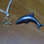 A silver dolphin brooch, and a gold plated pendant