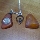 A 8ct gold mounted butterscotch amber pendant with Poseidon panel, height 51.6mm, and another,