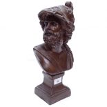 A patinated bronze effect bust of a man wearing a helmet decorated with animals, height 36cm