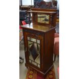 A late Victorian mahogany music cabinet, with a raised carved, panelled and mirror-back, a carved