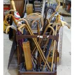 A mahogany stick stand with turned supports, containing walking sticks, tennis rackets, umbrella etc