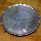 A 20th century presentation silver salver, with gadrooned edge and cast claw and ball feet, W31cm,