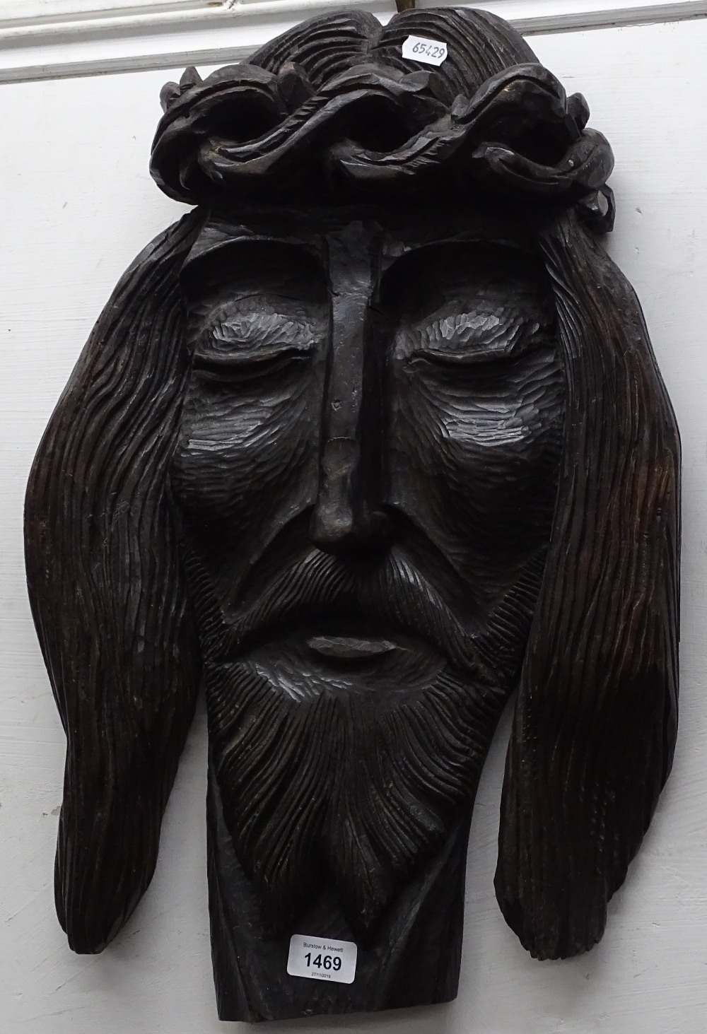 A carved wood plaque depicting the face of Jesus, L55cm