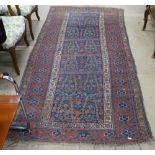 An Antique red ground Afghan rug, 235cm x 115cm