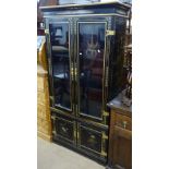 A Chinese design black lacquered cabinet, with 2 glazed doors, cupboards under, and gilded