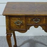 An 18th century walnut lowboy, with quarter veneered feather-banded top, 3 frieze drawers and