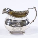 A George III silver milk jug, with bright-cut floral banding and beaded handle, maker's marks SH,