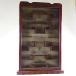 A Chinese hardwood snuff bottle display cabinet, with relief carved surround and stepped shelved