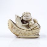 A Japanese Meiji period ivory netsuke, in the form of figures in a boat, length 4.5cm