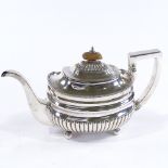 A George III silver oval teapot, of half-fluted form with turned wood finial and ivory insulator, by