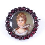 An Antique miniature painted portrait ceramic and faceted garnet brooch, in unmarked garnet gold
