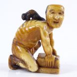 A Japanese carved ivory netsuke in the form of a rat catcher with a rat on his back, 18th or 19th