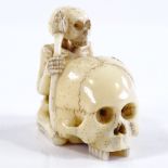 A Japanese Meiji period carved ivory skeleton and skull design netsuke, signed, height 4cm
