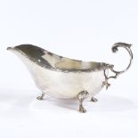 A silver gravy boat with hoof feet and C handle, by Walker & Hall, hallmarks Sheffield 1921,